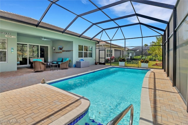 view of swimming pool with outdoor lounge area, glass enclosure, ceiling fan, and a patio area