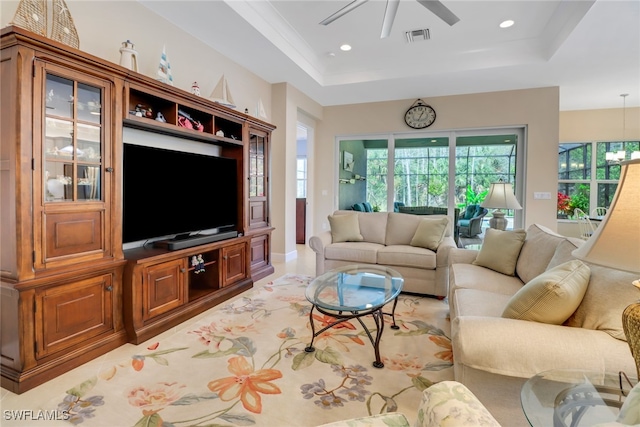 living room featuring a raised ceiling and ceiling fan