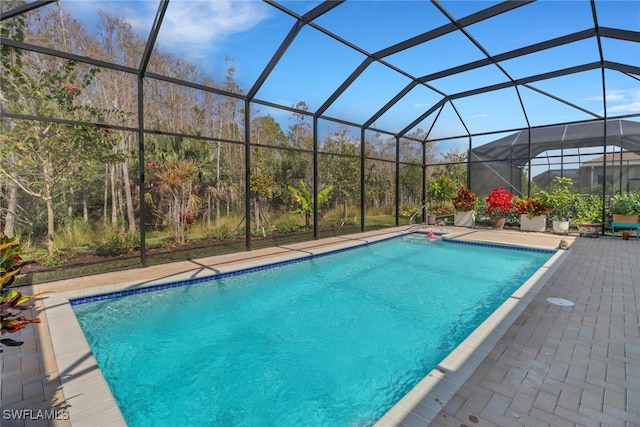 view of swimming pool with glass enclosure and a patio area