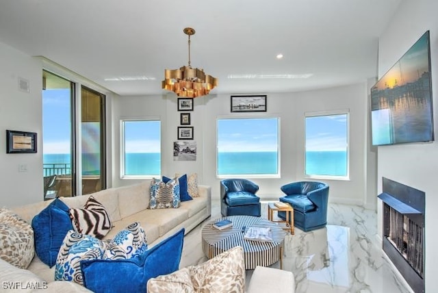 living room featuring a chandelier and a water view