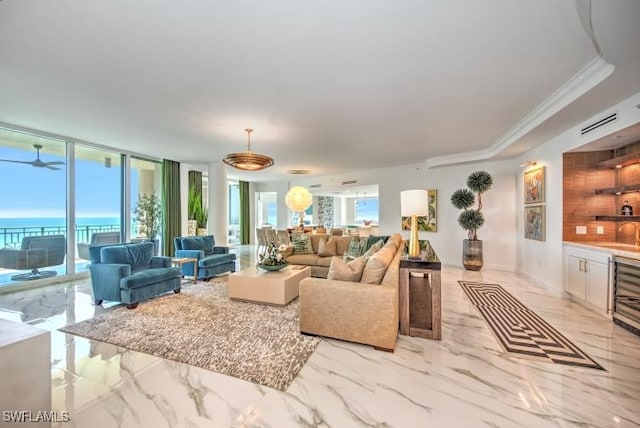 living room featuring a water view, ornamental molding, and sink