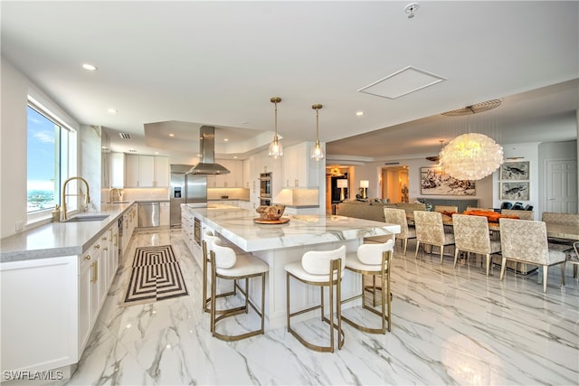 kitchen featuring pendant lighting, island range hood, and white cabinetry