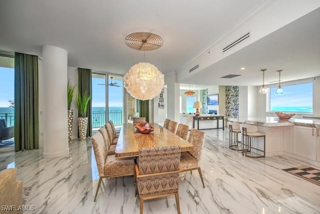 dining area featuring crown molding, plenty of natural light, a water view, and a wall of windows