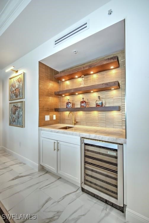 bar with tasteful backsplash, wine cooler, sink, and white cabinets