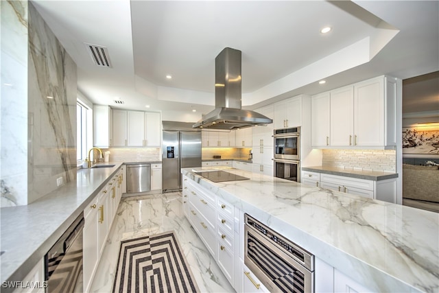 kitchen featuring light stone countertops, island range hood, white cabinets, and stainless steel appliances