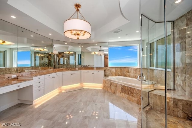 bathroom featuring plenty of natural light, separate shower and tub, vanity, and a tray ceiling