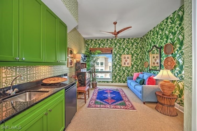 kitchen featuring dishwasher, sink, green cabinetry, ceiling fan, and light colored carpet