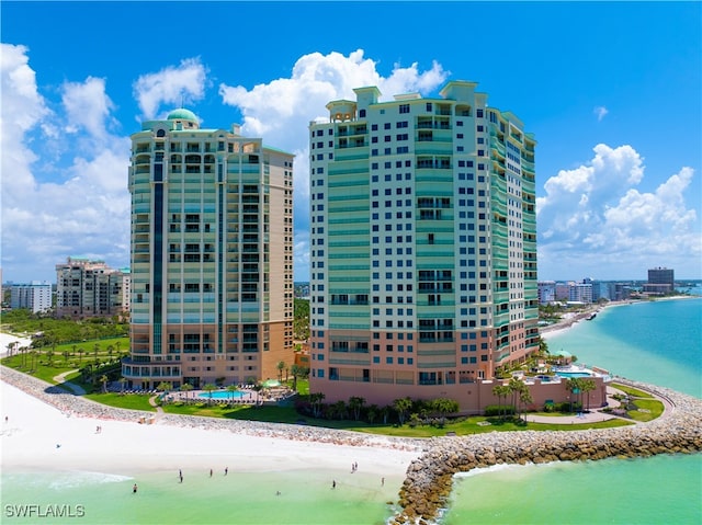 view of property with a water view and a beach view