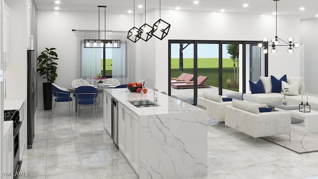 kitchen featuring decorative light fixtures, white cabinetry, a center island with sink, and sink