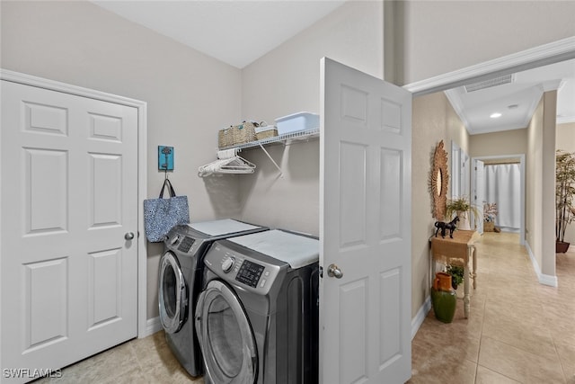 washroom with washing machine and dryer, light tile patterned floors, and ornamental molding