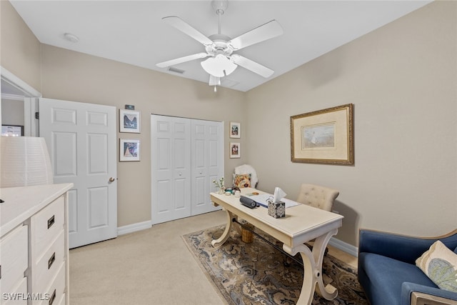 carpeted office space with ceiling fan