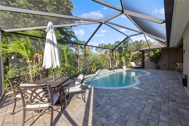 view of swimming pool with glass enclosure and a patio