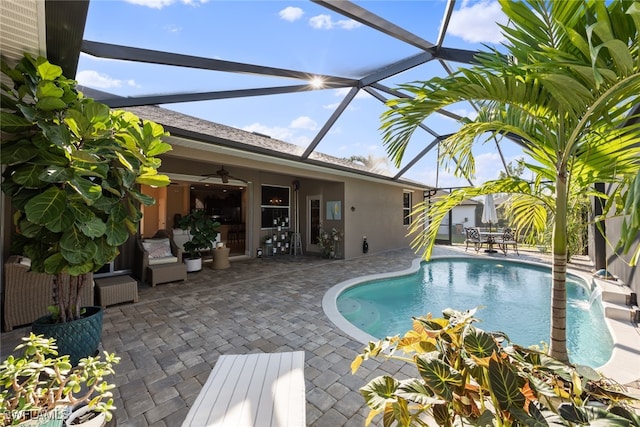 view of pool with a lanai, a patio area, ceiling fan, and pool water feature