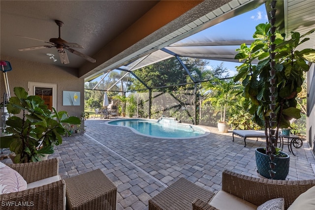 view of swimming pool with glass enclosure, ceiling fan, and a patio