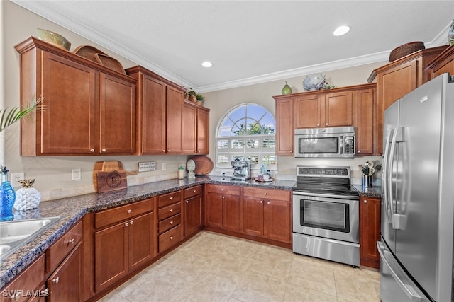 kitchen with crown molding, sink, dark stone counters, and appliances with stainless steel finishes