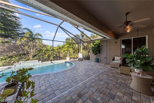 view of pool with a lanai, ceiling fan, and a patio