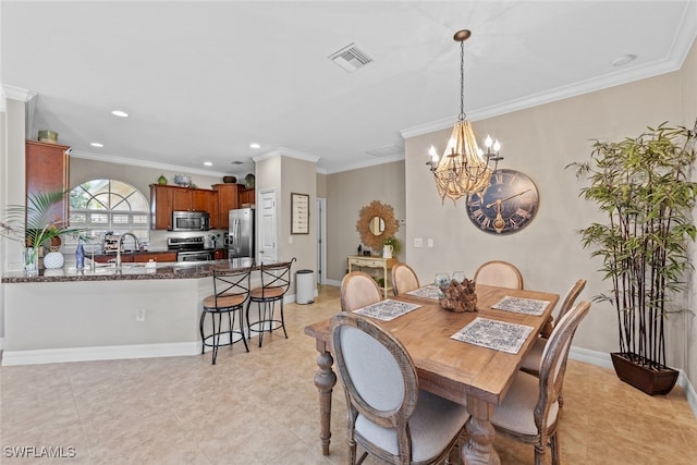 dining space with a chandelier, ornamental molding, and sink