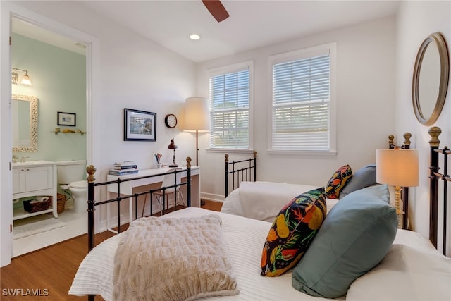 bedroom featuring hardwood / wood-style floors, ceiling fan, and ensuite bath