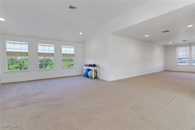 carpeted spare room featuring lofted ceiling