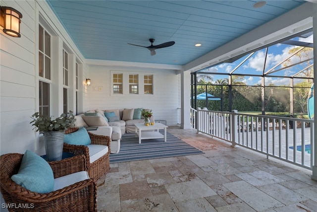 sunroom with ceiling fan and wooden ceiling