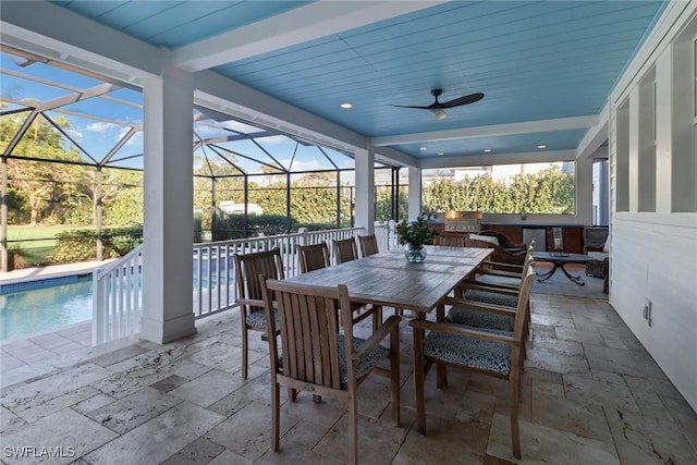 view of patio with an outdoor bar, area for grilling, ceiling fan, and a lanai