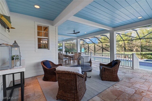 view of patio with glass enclosure and ceiling fan