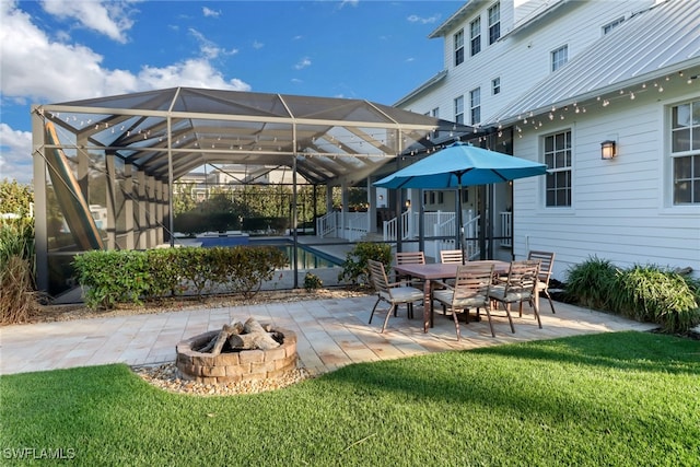 view of patio / terrace featuring glass enclosure and a fire pit