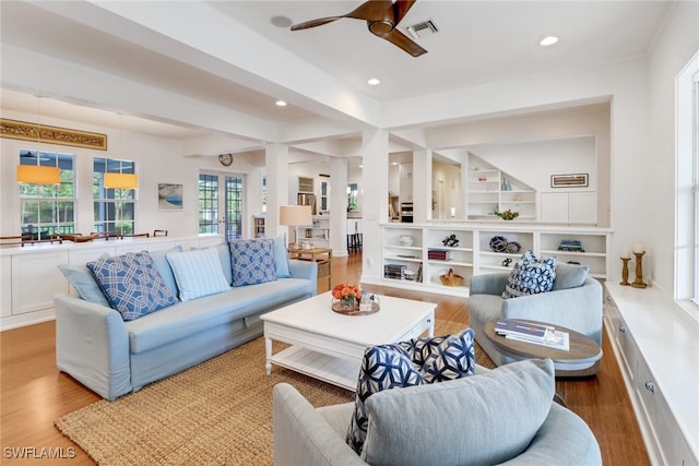 living room with ceiling fan, hardwood / wood-style floors, and beamed ceiling