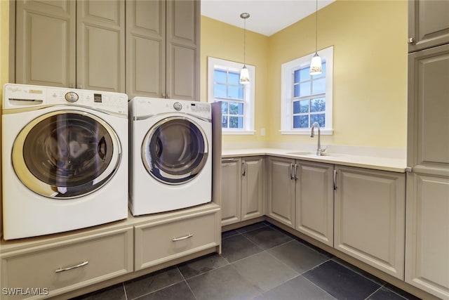 laundry area featuring washer and clothes dryer, cabinets, sink, and dark tile patterned flooring