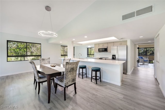 dining space with plenty of natural light, light wood-type flooring, and sink