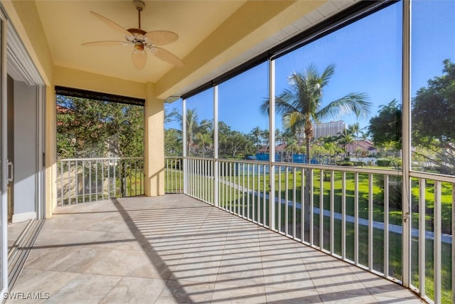 unfurnished sunroom featuring ceiling fan