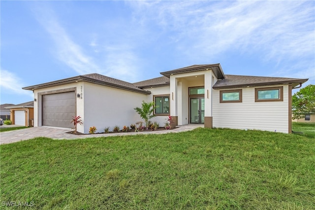 prairie-style home with a garage and a front lawn