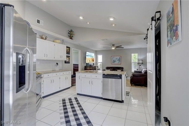 kitchen featuring ceiling fan, white cabinets, stainless steel appliances, and light tile patterned floors