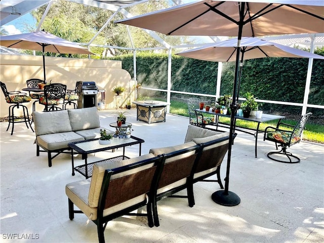 view of patio / terrace featuring a lanai, area for grilling, and an outdoor living space with a fire pit