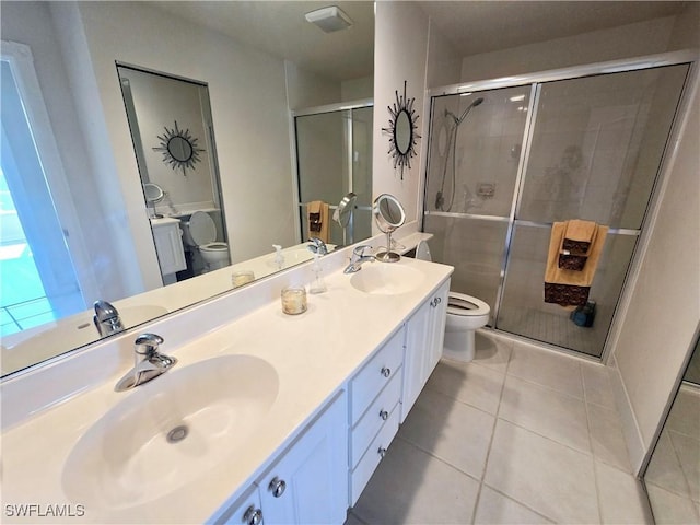 bathroom featuring tile patterned flooring, walk in shower, vanity, and toilet