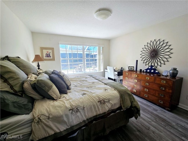 bedroom featuring dark wood-type flooring and a textured ceiling