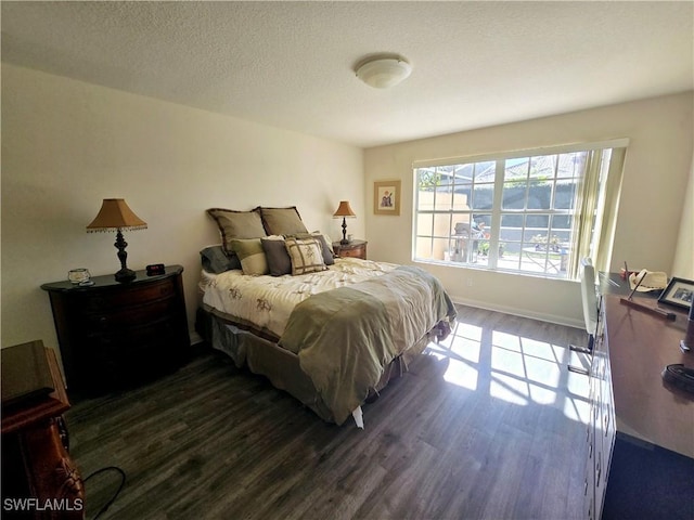 bedroom with a textured ceiling and dark hardwood / wood-style flooring