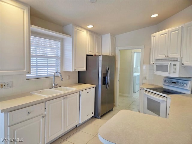 kitchen featuring white cabinets, white appliances, decorative backsplash, and a sink