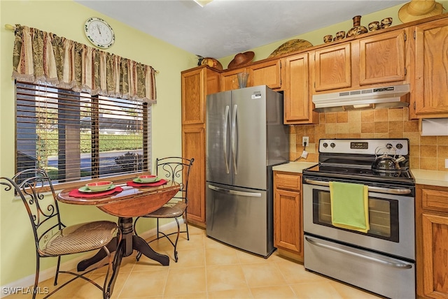 kitchen featuring backsplash, light tile patterned floors, and appliances with stainless steel finishes