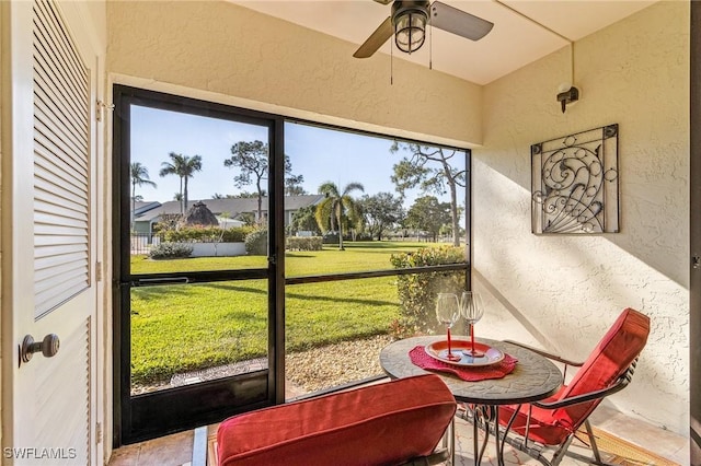 sunroom with a healthy amount of sunlight and ceiling fan