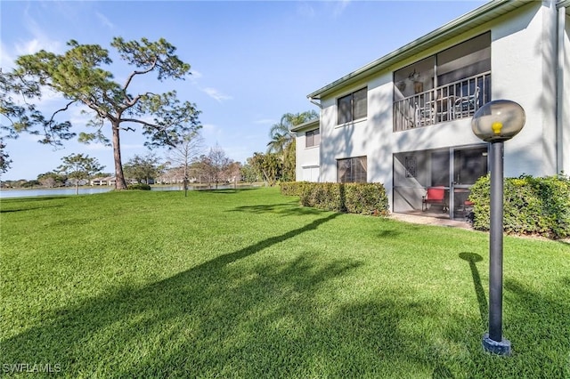 view of yard with a balcony and a water view