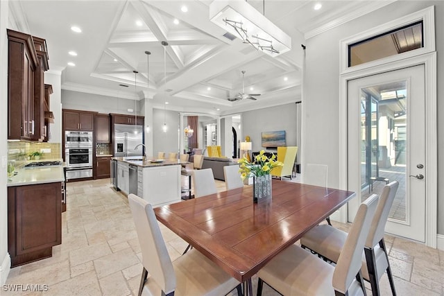 dining area featuring coffered ceiling, crown molding, sink, and beam ceiling