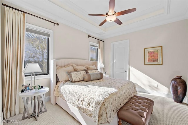 carpeted bedroom featuring crown molding, a tray ceiling, and ceiling fan