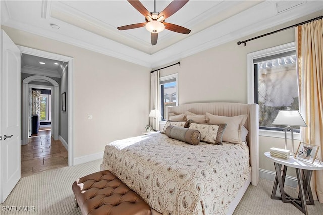 carpeted bedroom featuring crown molding, ceiling fan, and a tray ceiling