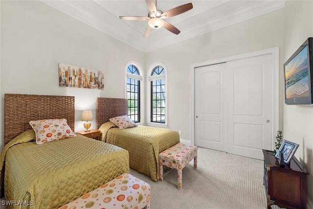 carpeted bedroom with crown molding, ceiling fan, and a closet