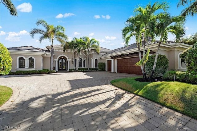 mediterranean / spanish house featuring a garage and french doors