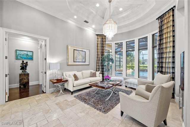 living room featuring a towering ceiling, ornamental molding, a tray ceiling, and a notable chandelier