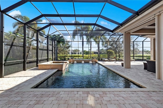 view of pool featuring an in ground hot tub, pool water feature, a lanai, and a patio area