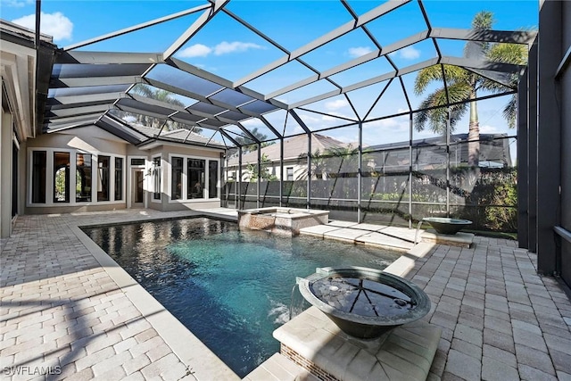 view of pool with an in ground hot tub, pool water feature, glass enclosure, and a patio