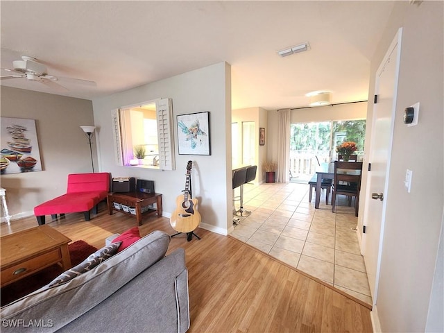 living room with light wood-type flooring and ceiling fan